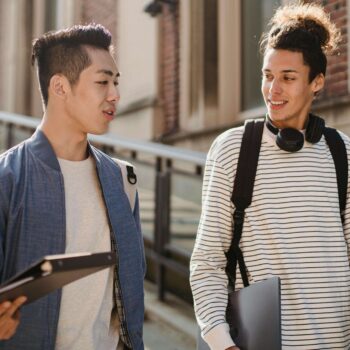 two college friends talking while walking